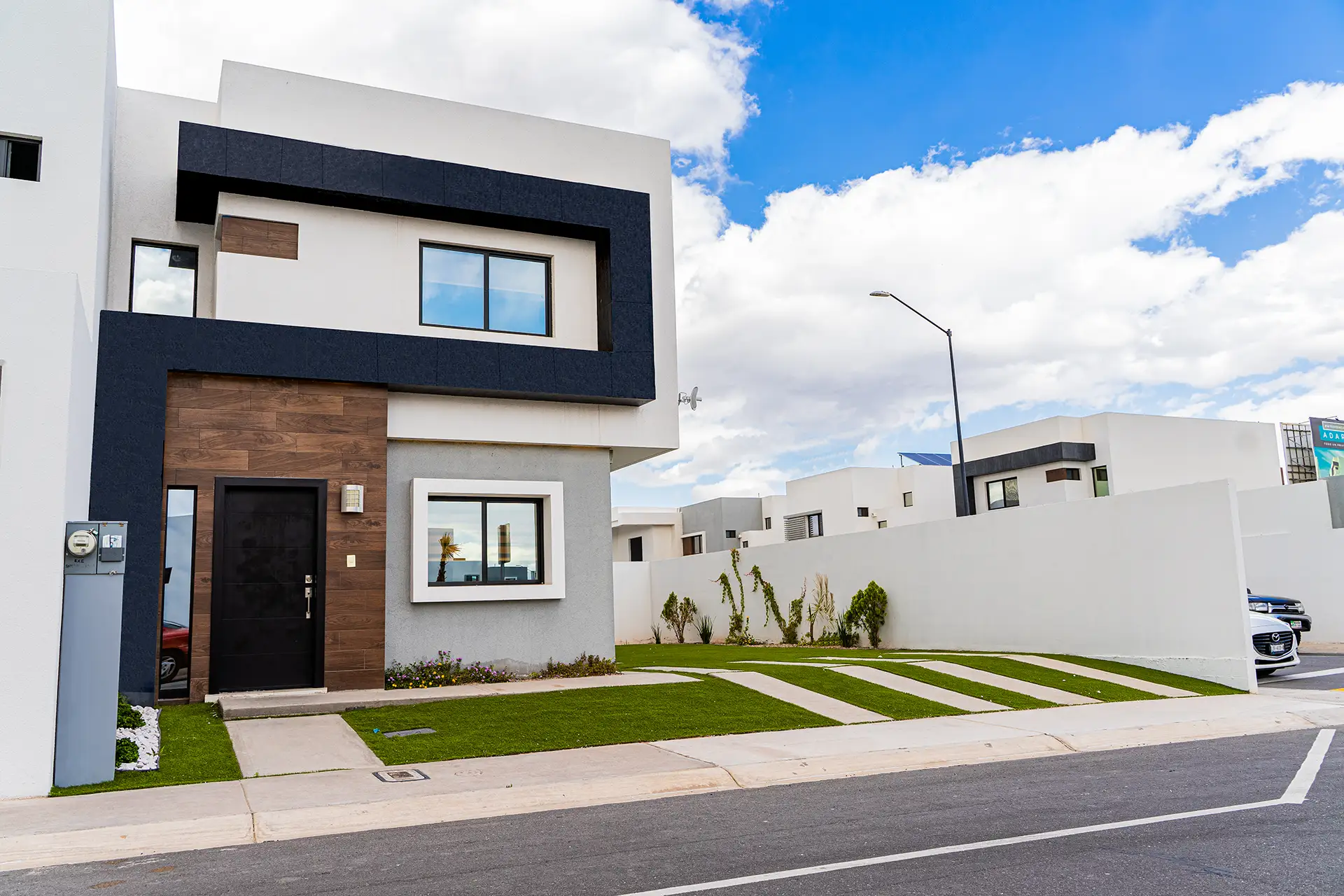 Facha de casa de dos pisos con patio y estacionamiento en Exe Adara.
