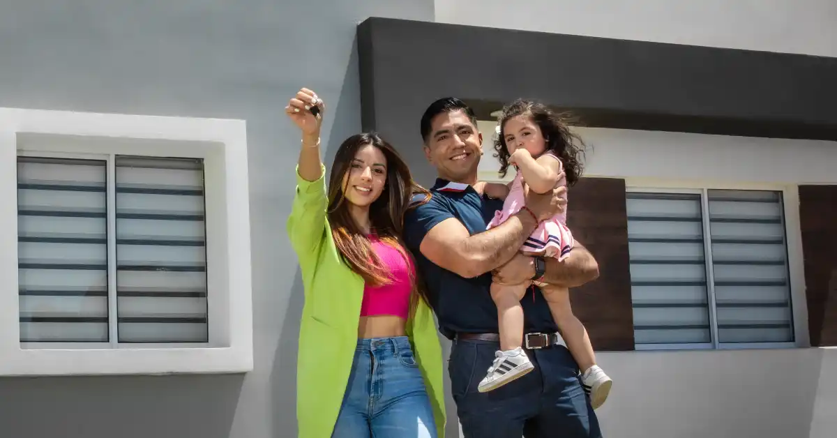 Familia posando al recibir las llaves de su nueva casa en Exe.