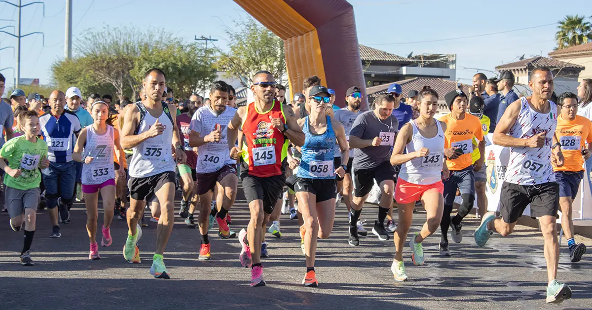 Grupo de personas en la linea de salida en carrera Somos EXE en Mexicali.