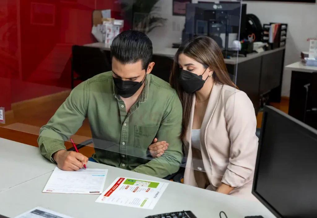 Recién casados firmando las escrituras de su casa nueva.