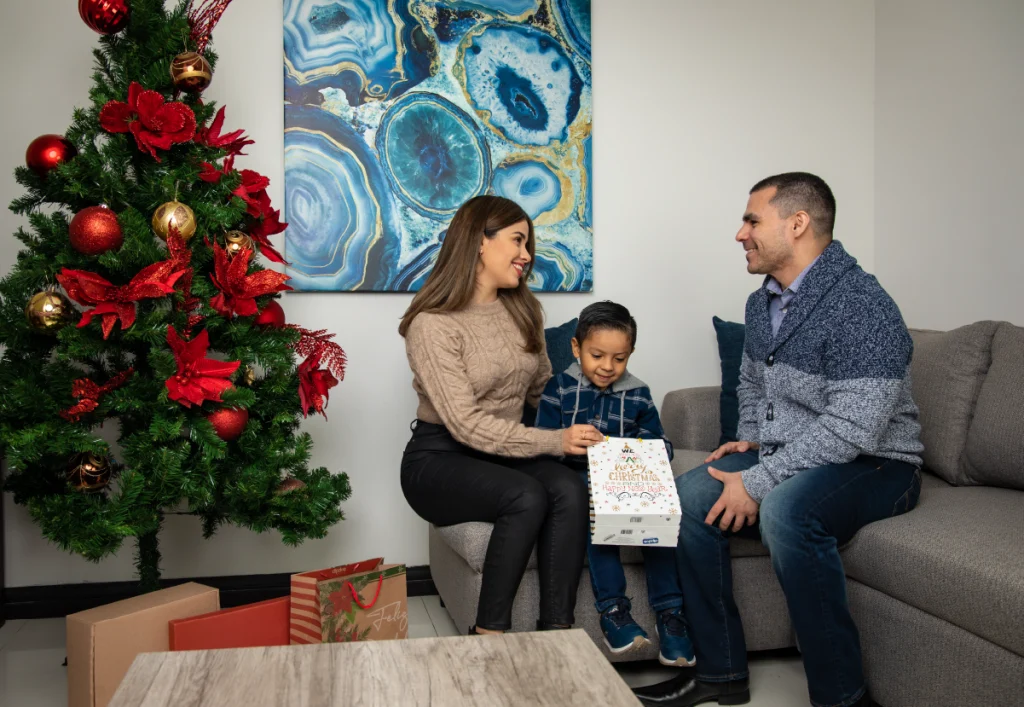 Familia intercambiando regalos navideños en su casa EXE