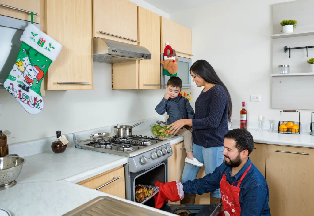 Familia cocinando cena navideña en casa nueva