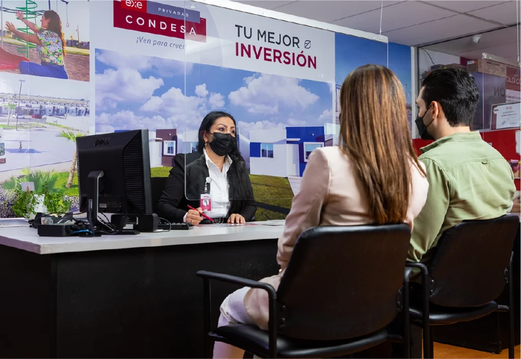 Asesor inmobiliario de EXE informando a pareja sobre las diferencias del crédito infonavit y el crédito bancario