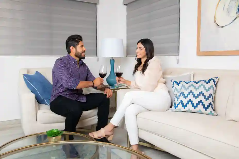 Retrato de pareja tomando vino en la sala de su hogar