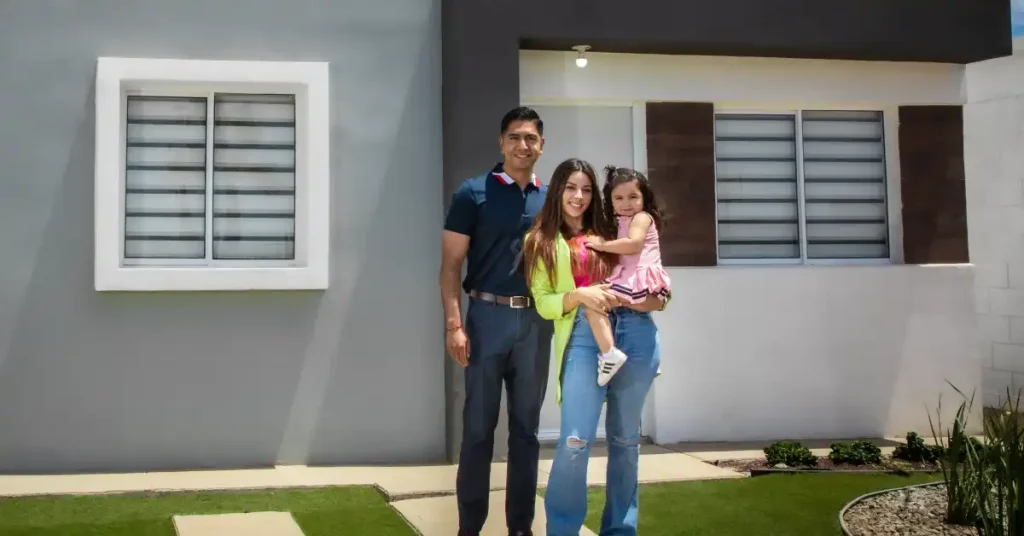 Familia posando frente a su nueva casa de Exe.